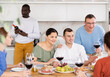 © JackF - Multiethnic women and men friends talking and drinking wine in the kitchen