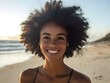 © bvbflo1 - A woman with an afro smiling at the camera on a beach