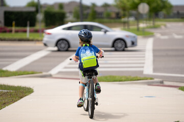 Little kid boy ride a bicycle in the park. Kid cycling on bicycle. Happy smiling child in helmet riding a bike. Boy start to ride a bicycle. Sporty kid bike riding on bikeway. Kids bicycle.