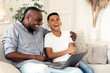 © Prostock-studio - Joyful Time With Grandpa. Preteen Black Boy And His Grandfather Watching Comedy Movie On Laptop And Laughing Together At Home
