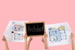 © Pixel-Shot - Women holding chalkboard with word ARCHITECT and house plans on pink background