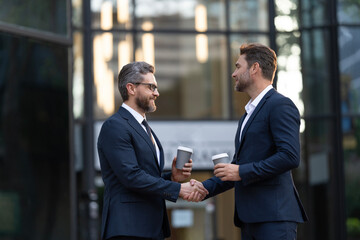 Wall Mural - Businessmen handshaking after contract deal. Successful agreement in business deal. Businessmen dealing outdoor. Partnership concept. Handshaking. Business partnership. Business deal. Copy space