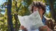 © Stock_Maker - Young Man Smiling While Reading a Letter Outside