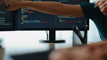 Slow motion back end software developer engineer for computer programming working together on debugging writing computing code, solving complex algorithms display on monitor in office. Burgeoning