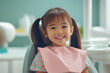 © Thodsapol - Cheerful young girl smiling during a dental checkup, sitting in the dentist’s chair.