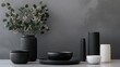 © Dragon42 - Minimalist Black and White Ceramic Vases and Bowls on a Gray Background with Greenery