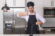 © Volodymyr - Happy baker with thumb up. Portrait of chef, cooks or baker. Man in cook hat and chef uniform cooking on kitchen.
