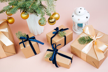 Christmas gifts in craft paper with a blue bow. Eco friendly trendy zero waste packaging, holiday mood concept, making gifts. 