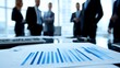© loxia stock image - Blurred background of businesspeople in meeting with financial charts in foreground.