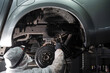 © Михаил Решетников - The master sprays an anti-corrosion compound on the bottom of the car.