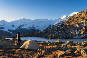 Fototapete - A hiker enjoying his coffee at a beautiful campsite in the Bernina mountain range. Switzerland.