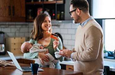 Wall Mural - Parents with infant child having video call on laptop at home. Family happiness technology concept.