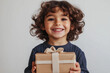 © KEA - a happy child holds a gift in his hands, smiles and looks at the camera