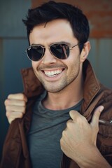 Poster - A man with sunglasses and a brown jacket, standing in a casual pose