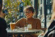 © Vii - A woman sits at a table with a glass of beer, enjoying her drink
