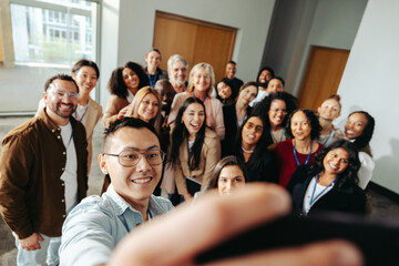 Wall Mural - diverse group taking a cheerful selfie at a successful seminar to capture a memorable moment of team