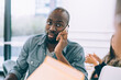 © BullRun - Black man making call on smartphone in office