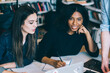 © BullRun - Charming multiracial woman looking at camera with smile while students working on project at table