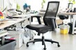© Trionorejo - An office chair in a cluttered workspace with papers and supplies.