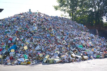 large pile of discarded aluminum cans and metal waste outdoors.