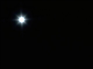 Wall Mural - a lone star shines brightly against a backdrop of deep blackness, its light piercing through the dar