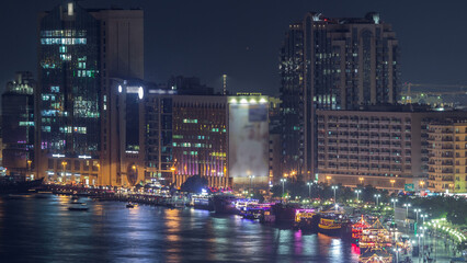 Wall Mural - Dubai creek landscape night timelapse with boats and ship near waterfront