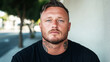 © Axel Bueckert - Serious man with neck tattoos posing in urban setting