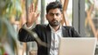 © COK House - Indian man in suit with laptop, serious expression, making 'stop' gesture in professional setting, shows authority or emphasis.