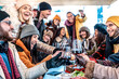 © charmedlightph - Group of young people toasting red wine at restaurant patio - Happy multiracial friends wearing winter clothes having fun at winery bar table - Dining life style and friendship concept