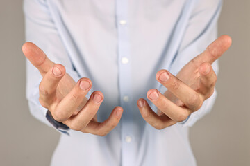 Wall Mural - man holding something on grey background, closeup