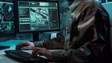 Military soldier operating advanced technology in a command center.