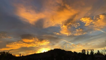 Wall Mural - Incredible morning sky brings warm and cool colors before the sun rises over forest hill side, time lapse.