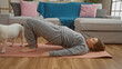 © Krakenimages.com - A young blonde caucasian woman doing yoga with her canine pet in a cozy living room.