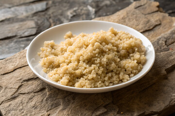 Poster - quinoa in a plate on a stone background