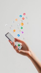 Poster - Hand holding a smartphone with colorful social media icons floating above, representing the connectivity and communication in the digital age, against a minimalist white background
