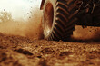 © Michael - Close-up of tractor tire kicking up dust while driving on dirt road