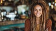 © Maximages  - A woman with dreadlocks smiles widely in an artsy, rustic cafe, radiating friendliness and authenticity, creating a comforting blend of natural beauty and charm.
