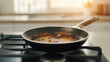 © Bonsales - Food residue burned in frying pan on stove top, symbolizing kitchen mishaps and cleaning difficulties
