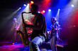 © Zamrznuti tonovi - Saxophonist performing with band on stage under colorful lights