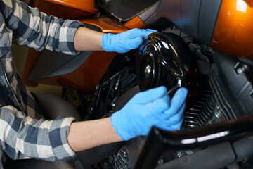 Poster - Skilled hands working on a motorcycle engine in a garage workshop space