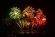 Colorful fireworks celebration with people and the city night light background at the seaside. International firework festival at Pattaya, Thailand.