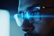 © Atlas Studio - Close-up of an Individual Wearing Glasses, Focused Intently on a Screen With a Blue Light, Reflecting Concentration