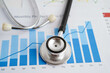 © manassanant - Stethoscope on chart or graph paper, Financial, account, statistics and business data medical health.