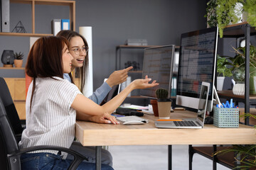 Female programmers working at table in office