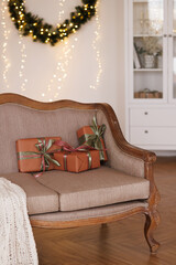 Wall Mural - Brown retro sofa in living room with parquet with Christmas wreath on white wall. Stylish Christmas decorations concept for home.