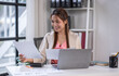 © David - asian business woman working in office checking documents. young businesswoman accounting manager executive or lawyer using laptop reading paper file financial report, tax invoice.