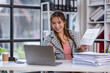 © David - Portrait successful businesswoman, asian woman shows a report of financial documents online interlocutors in the laptop screen, an employee inside an office building online video conference.