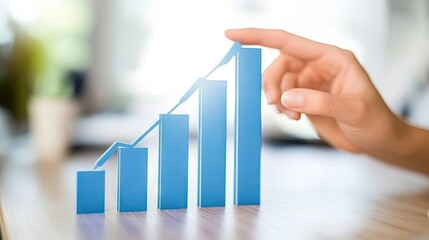 Hand demonstrating a rising graph representing growth in business performance, success, and progress in a modern office environment with blurred background