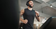 © Coetzee/peopleimages.com - Man, headphones and running on treadmill at gym for exercise, training and cardio workout. Fitness, happy athlete and listening to music or radio on machine for marathon endurance and speed challenge