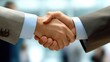 © Napasnan - Close-up of business handshake, symbolizing communication and partnership, with a blurred office background